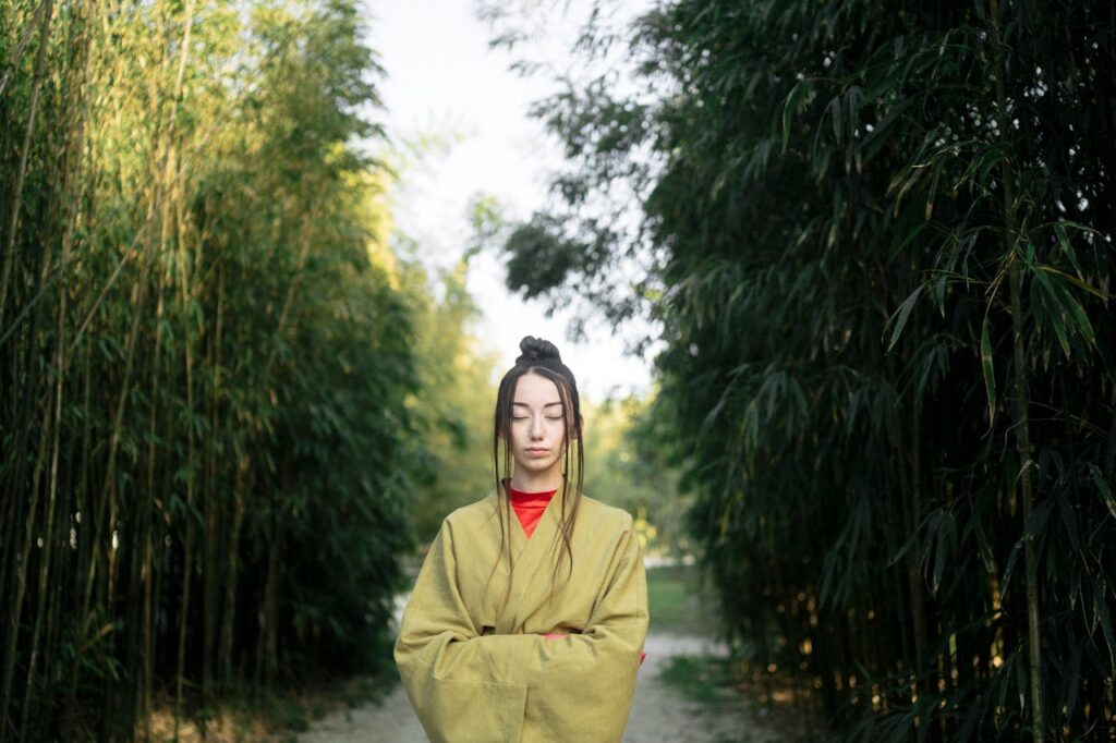 Philosophie et coaching : vers une écologie personnelle éclairée (image décorative d'une femme fermant les yeux au milieu de bambous)